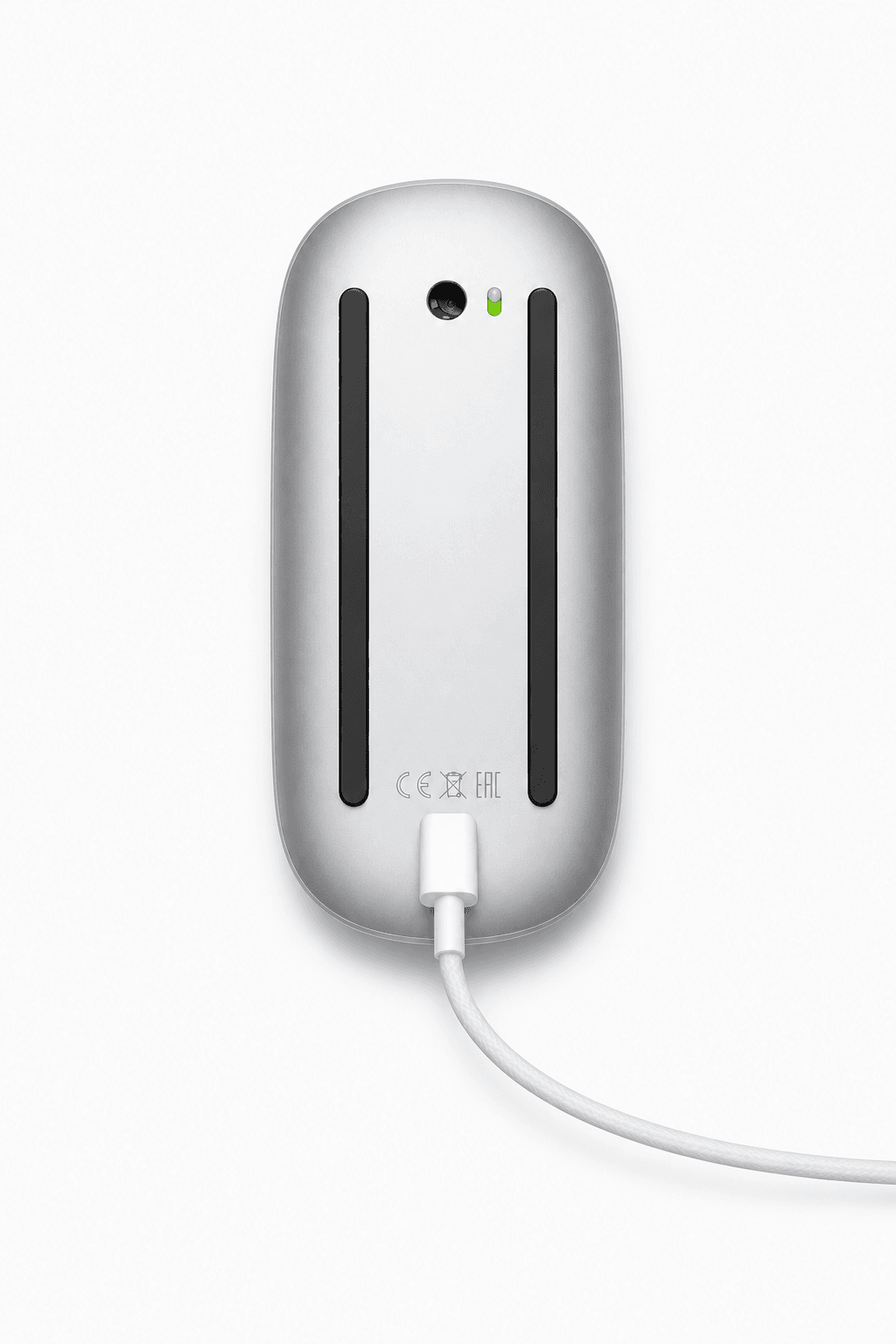 Underside of a silver Magic Mouse connected to a charging cable